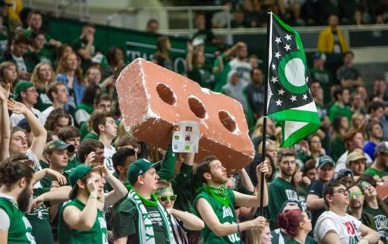 Ohio Bobcat student fans cheer and hold a giant foam brick at a basketball game